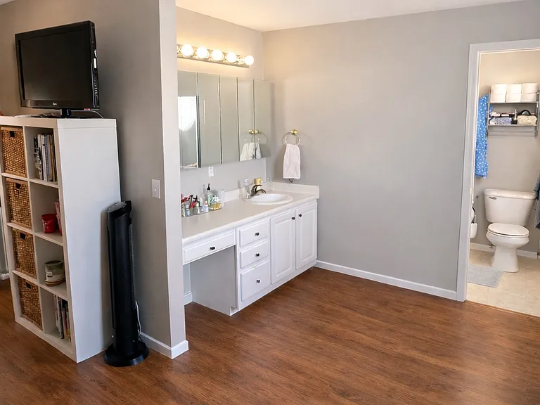 Primary suite vanity area and full bath with new flooring and paint