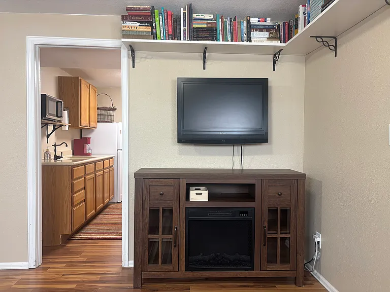 Kitchen entry from living room. TV for use with tenants' streaming accounts. WiFi is included in your utilities. Electric Fireplace for additional climate control in the Apartment.