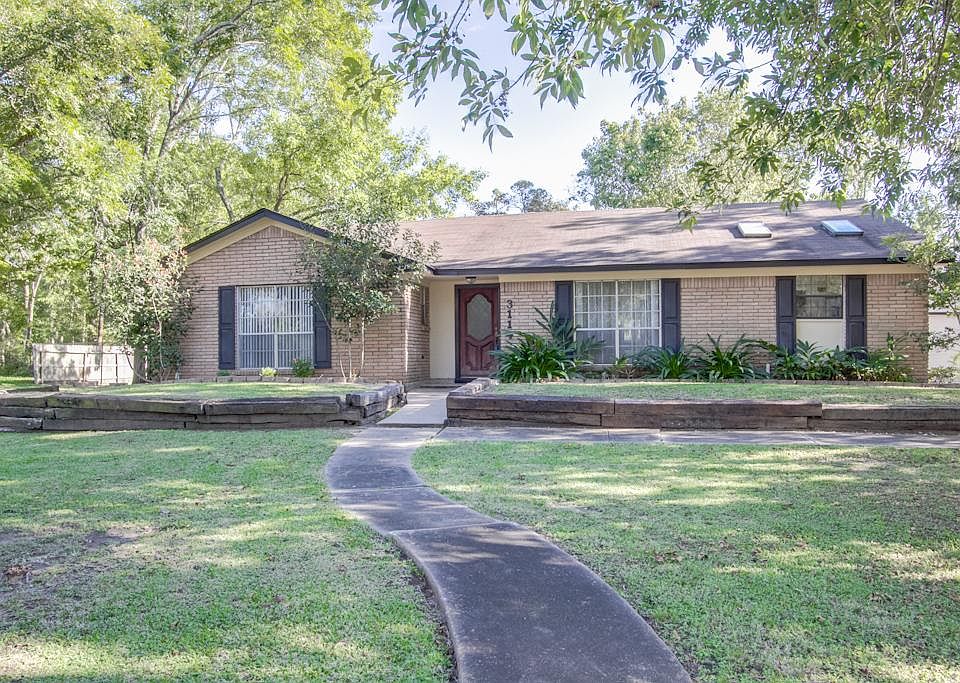 Home with nice landscaping and mature trees.