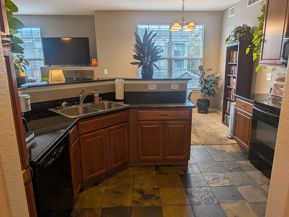 Kitchen features granite counters, maple cabinetry, full length pantry, sleek black appliances, and plenty of natural light from the full sized windows
