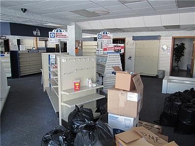 Pharmacy- behind the glass window is the interior room. The dark room on the left is the large office and the dark room to the right is the large storage area.