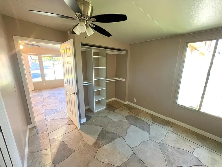 Bedroom with plenty of closet space and large window facing the sunrise. .