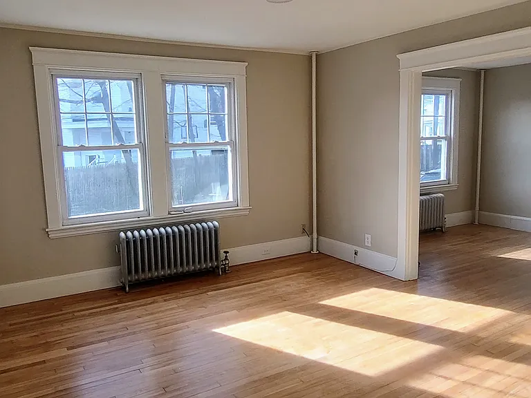 The living room has big, bright windows.