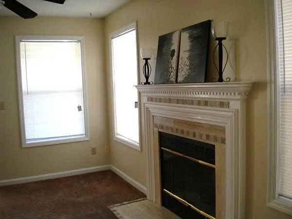 Fireplace in living room has nice mantel & decorative tiles.