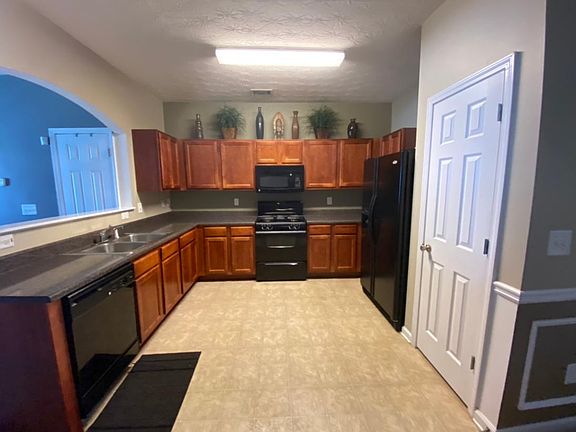 The spacious kitchen features a gas range, above range microwave, dishwater, ample cabinet space, and a pantry.