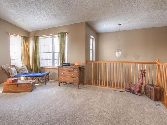 Spacious upper level living area with large windows and neutral decor.