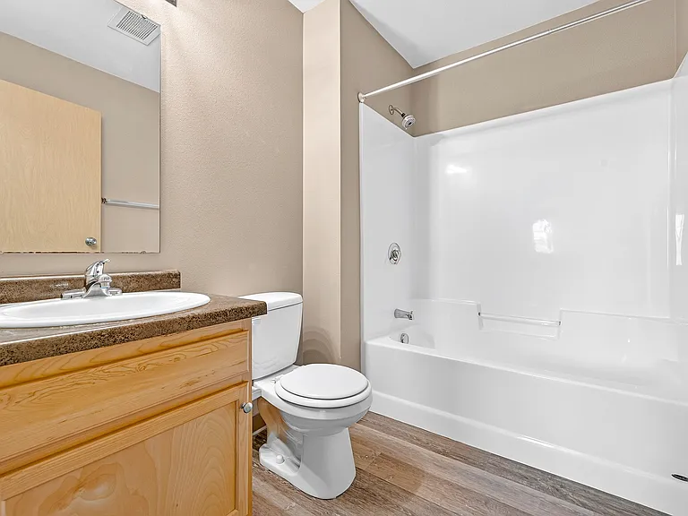 Step into a beautifully designed bathroom at Minot Place Apartments, featuring modern fixtures and stylish finishes for your comfort. This serene space is perfect for relaxation and rejuvenation. Schedule a tour today to see it for yourself!