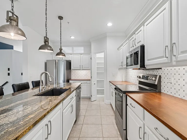 Gourmet kitchen with natural granite island and butcher block countertops