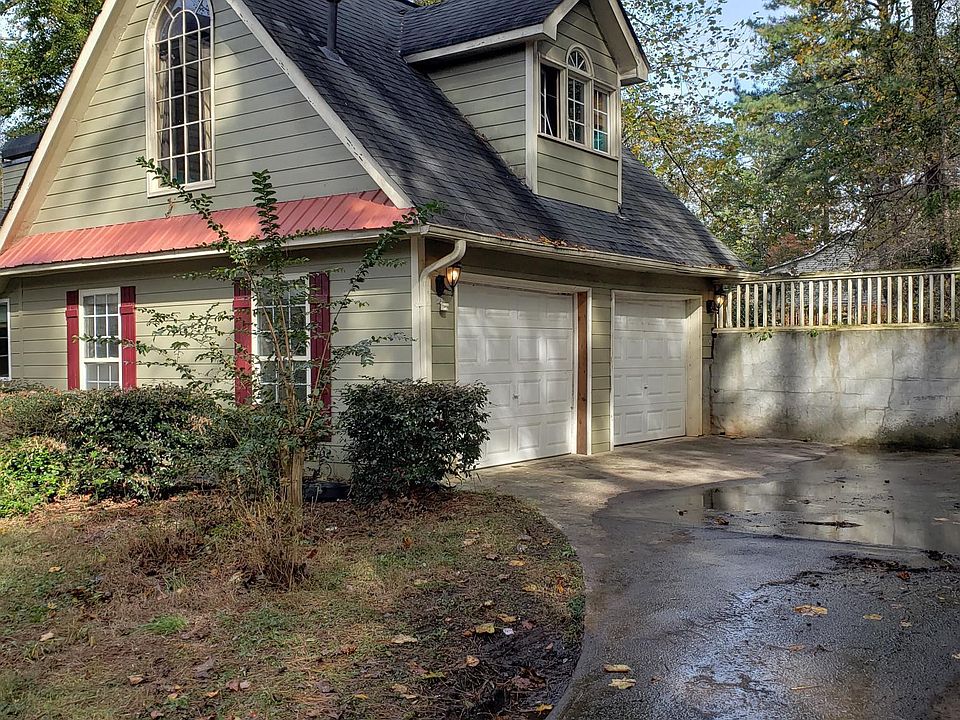 Driveway view of garage with studio apartment over it showing kitchen window. Both garages and sunroom included with studio apartment