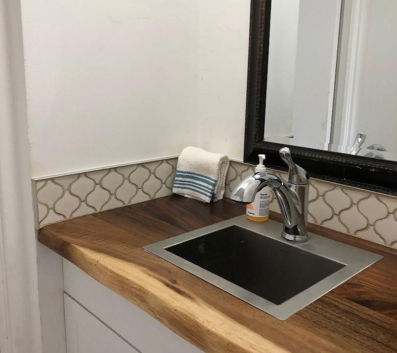 Vanity area with bar sink and disposal.