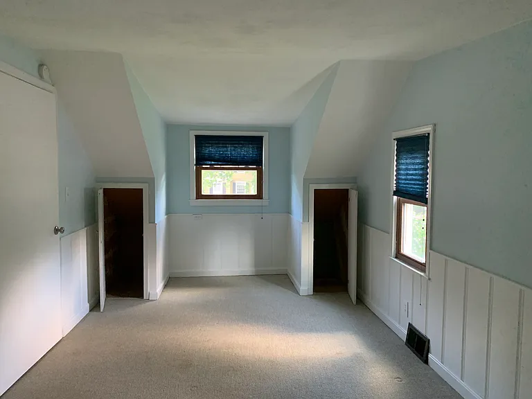 Second bedroom on second floor with 2 closets, 2 storage cabinets, and shelves. Additional large storage closet between bedrooms.
