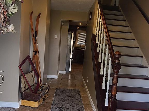 Front entrance view, stairs & kitchen.