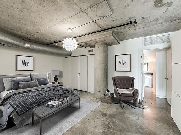 The 2nd floor Primary Bedroom is nicely sized at approx 19'x13' (Buyer to verify). Polished cement floors throughout the entire unit. Wall mounted dresser on far right wall included. Barn doors on left is walk-in closet and Primary Bath seen on right