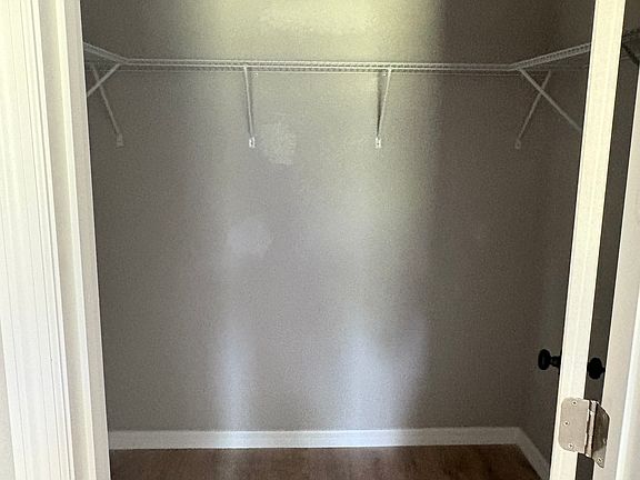 Master walk-in closet with a convenient upper shelf for added storage.