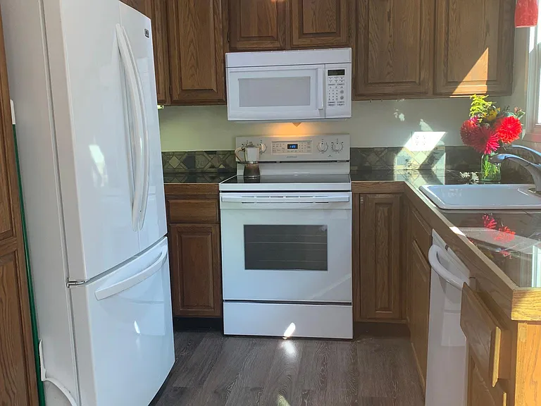 Sunny kitchen with all new appliances overlooks backyard