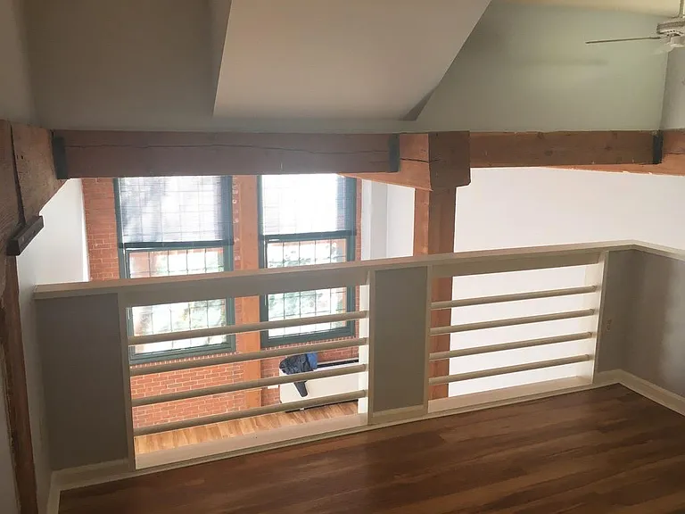 Bedroom overlooking the living room and windows to courtyard garden