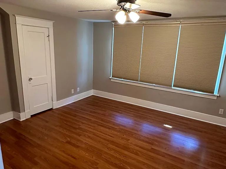 Large primary bedroom with two walk in closets and custom room darkening/light filtering shades.
