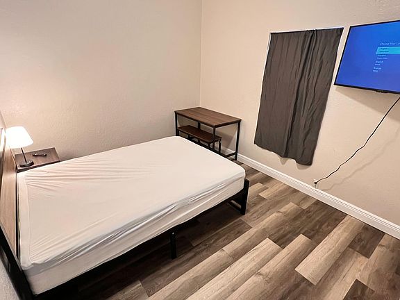 Furnished room near entrance and common area with work desk and relaxing space. Shared bath and on-site parking available.