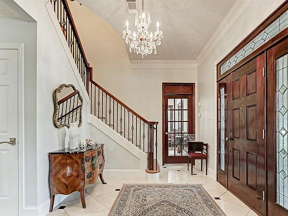 Another view of the entry showing crystal chandelier, polished marble floors, large walk-in closet under the stair well, and access to the first study.