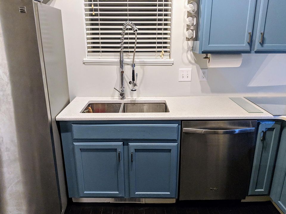 Quartz countertops, deep stainless steel sink, and industrial-grade kitchen faucet.