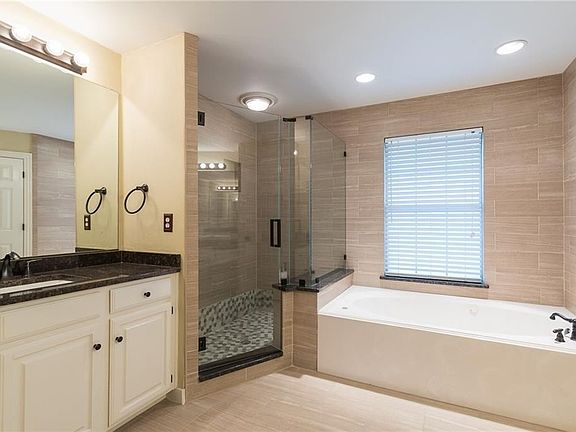 This den looks into the pool area and the kitchen. So does the breakfast area in the far right. Notice all the expensive upgraded fans and light fixtures.