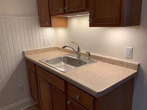 New kitchen cabinets showing under-cabinet lighting. Ample counter space for toaster and/or microwave oven.