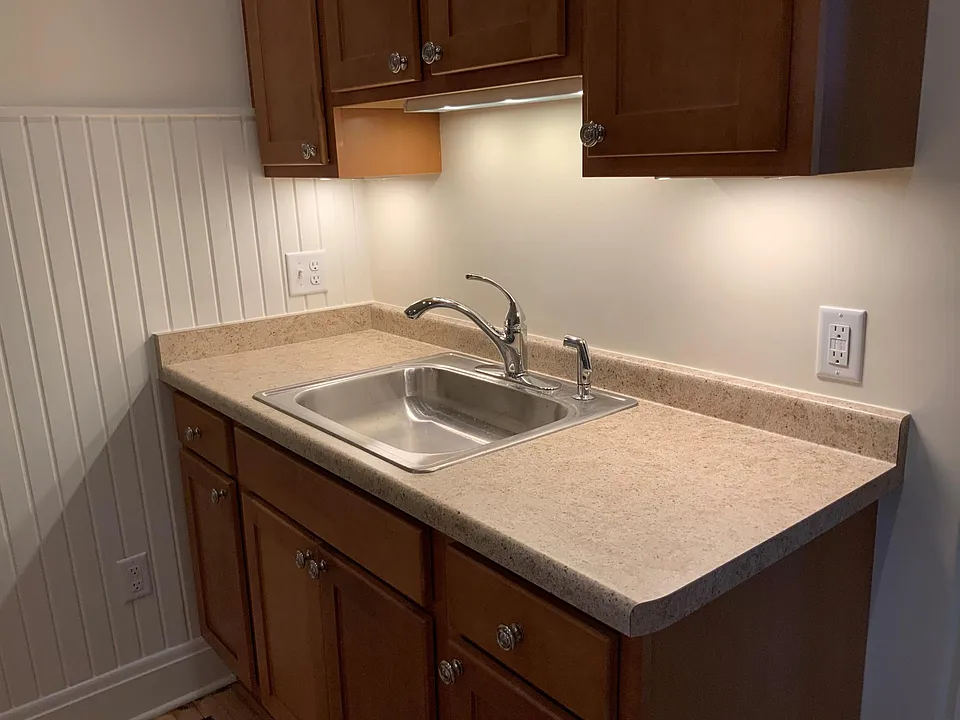 New kitchen cabinets showing under-cabinet lighting. Ample counter space for toaster and/or microwave oven.