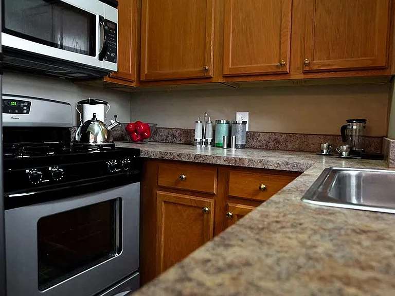 Updated galley kitchen with stainless steel appliances.