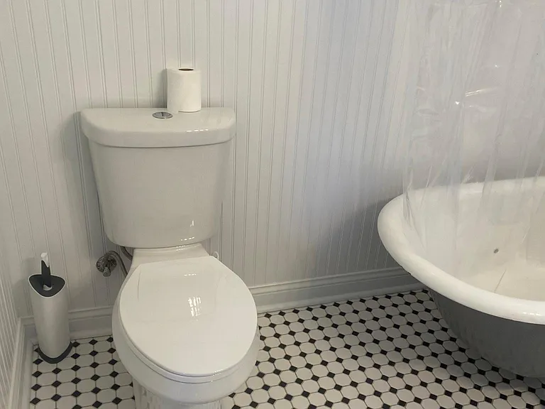 Bathroom with beautiful tile floor, wainscotting, and clawfoot tub