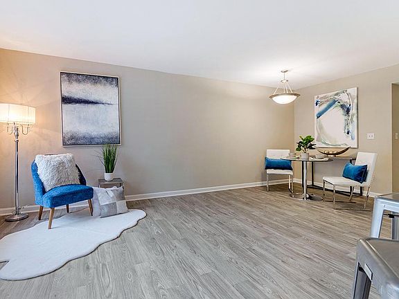 Relax in your spacious living room featuring wood-style flooring and large windows.