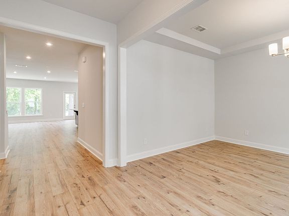 The foyer welcomes guests with its grandeur and polished hardwood floors.