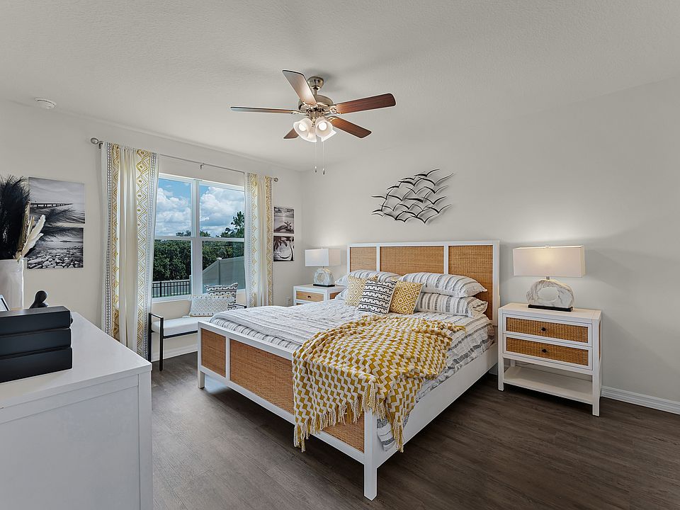 Bright and spacious primary bedroom with large window and modern ceiling fan.
