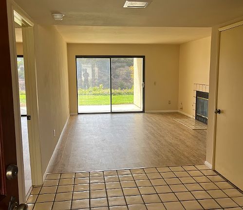 View onto unit from the entry door. Note that the sliding window now has new vertical blinds .