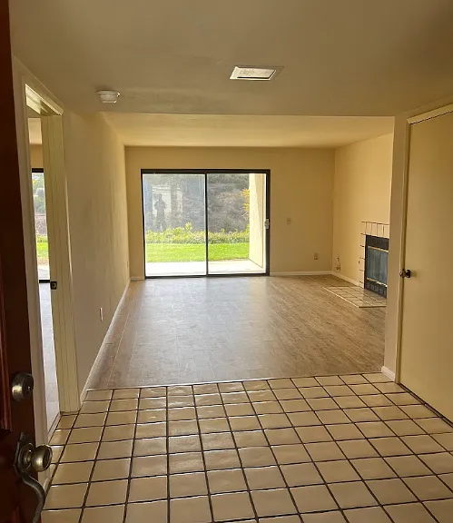 View onto unit from the entry door. Note that the sliding window now has new vertical blinds .