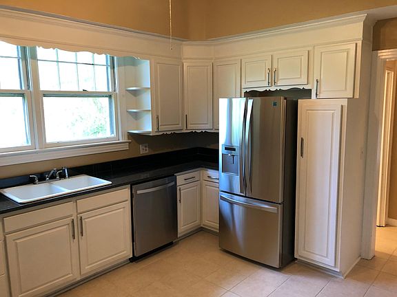 Stainless Steel Dishwasher and Side By Side Refrigerator with Bottom Freezer - Ice and Water Dispenser in door. Ceramic Double sink. Beautiful White Custom Cabinets - Black Granite Counter Tops.
