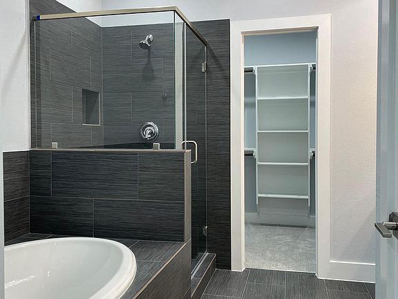 Primary bathroom with double vanity and wet room (closed door)