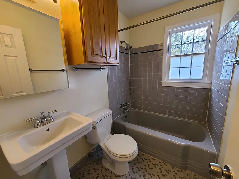 The hallway bath wih updated cabinetry, sink and medicine cabinet.