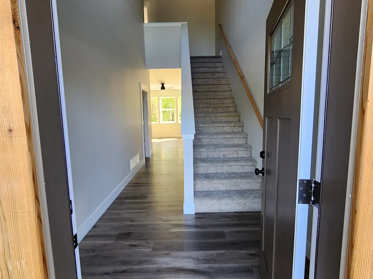 Spacious entryway with high ceilings, and broad hallway and carpeted stairway