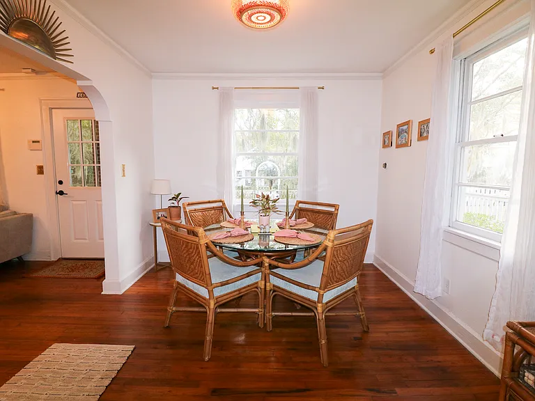 Dining area features a four person table, original hardwood floors, and tons of natural light