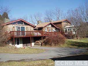Rear of house with garage entrance, deck, and sunroom