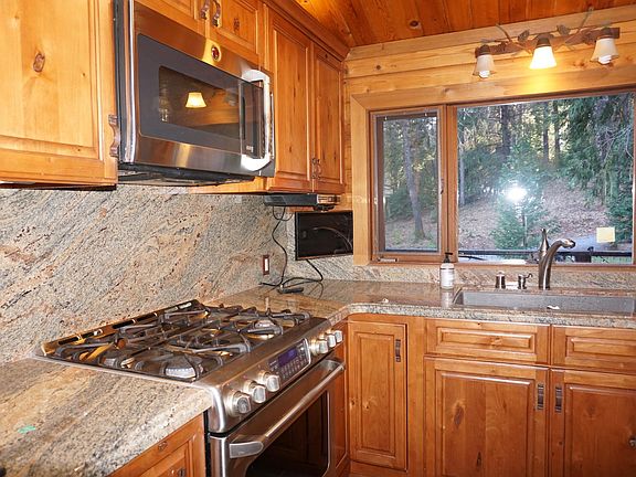 Kitchen, granite, gas range and electric stove, Adventium Microwave, granite sink with view of the lawn.