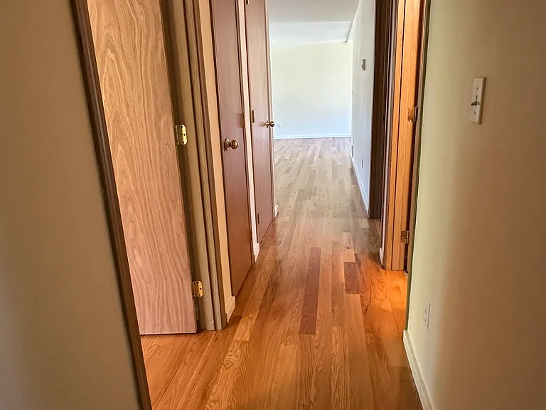 Downstairs hallway serving 2 bedrooms, laundry room, guest bath, linen and coat closets.