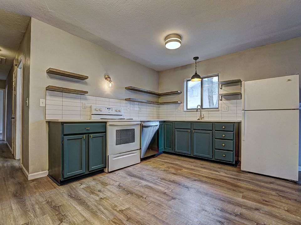 Fully refinished kitchen that's adorable with floating shelves and gold/black accents.