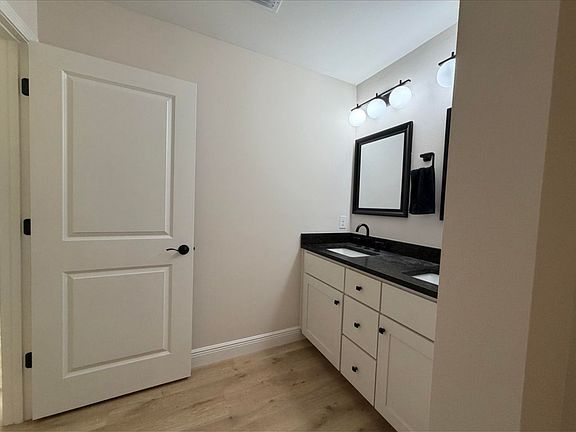 Double vanities in the master bathroom with leathered granite countertops