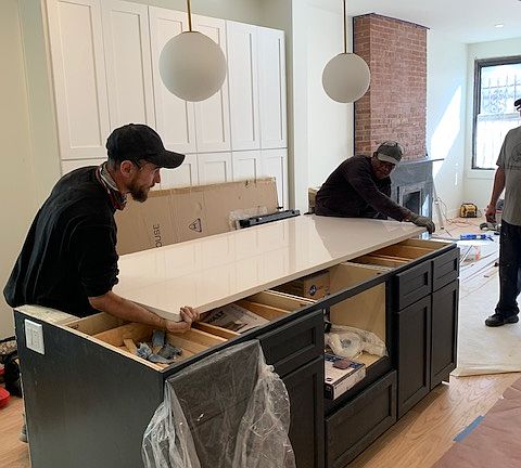 This in-construction photo shows the installation of new Kitchen cabinetry, and quartz island countertop.