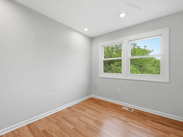 Primary Bedroom with Hardwood Floors and Natural Light