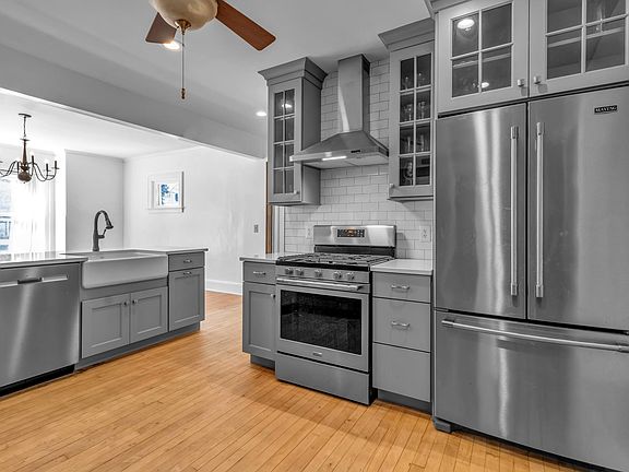 kitchen with subway tile backsplash and new stainless steel appliances (showing island into dining room)