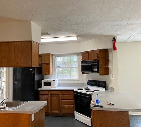 Kitchen and overhang bar to Fun Room with Built in Bar