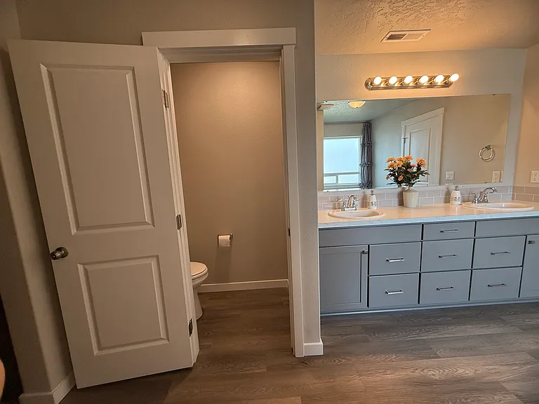 Primary bathroom featuring separate toilet area with a privacy door.