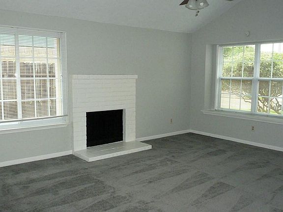 Light and bright living room with high ceilings, new ceiling fan, carpet and paint. beautiful window